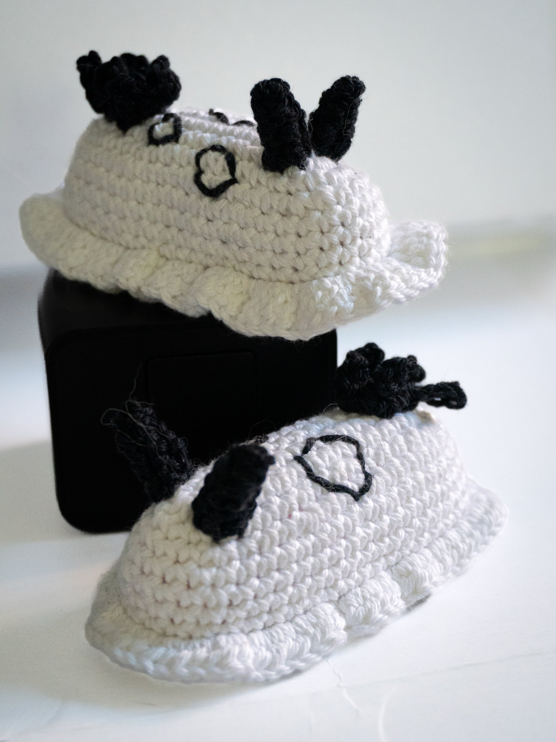 Crocheted black and white cat costume on a white background