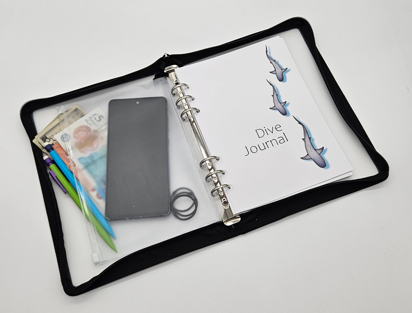 A5 size dive logbook with protective zip cover shown next to mobile phone for scale